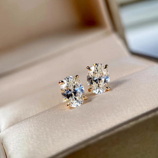 Pair of diamond stud earrings on a soft fabric background