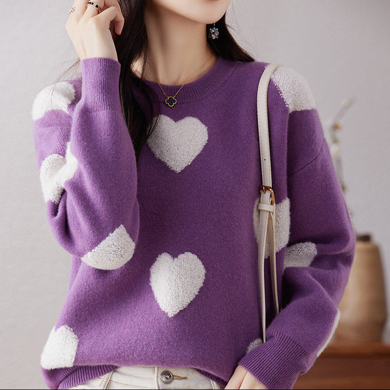 Person wearing a purple sweater with white heart patterns against a neutral background
