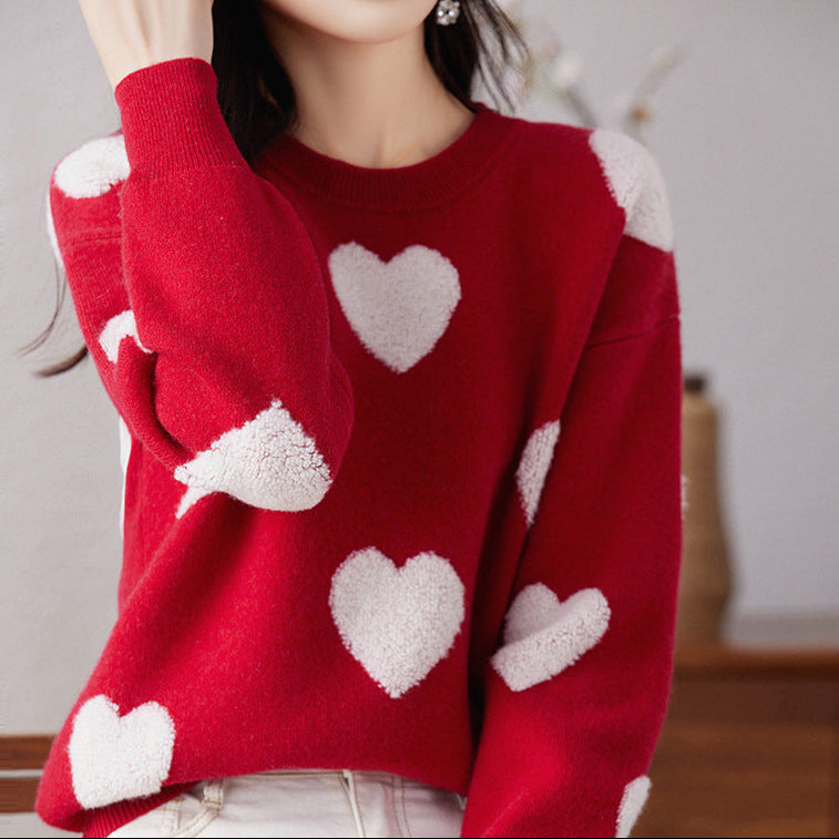 Red sweater with white heart patterns worn by a person.