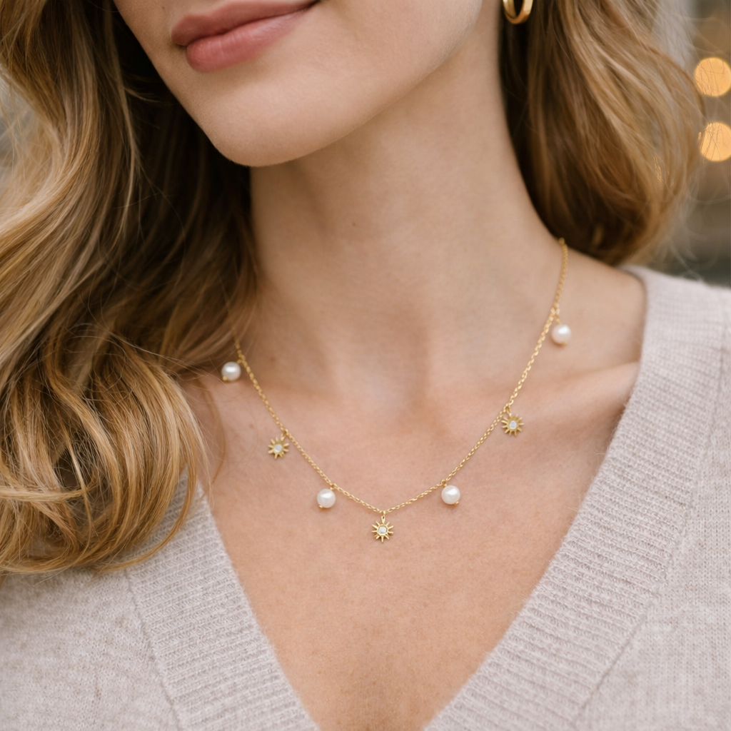Close-up of a woman wearing a delicate gold necklace with pearls and star-shaped charms.