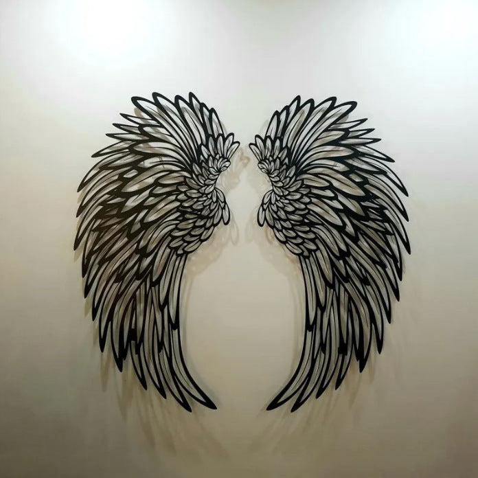Black metal angel wings on a white wall