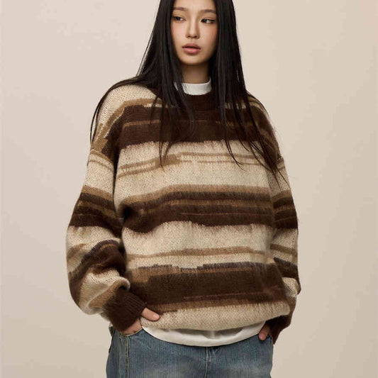Person wearing a brown and beige striped sweater on a plain background