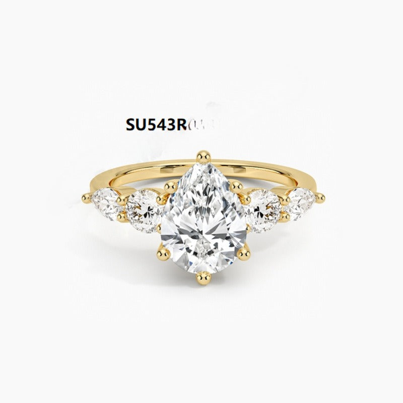 Gold ring with a large diamond and smaller diamonds on the sides against a white background.