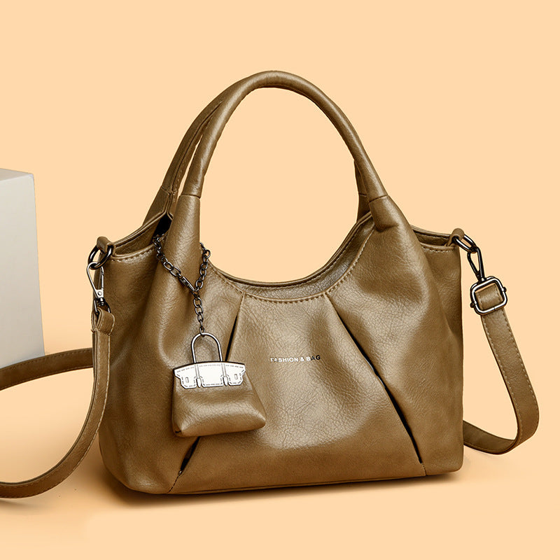 Brown handbag with a small attached pouch on a beige background