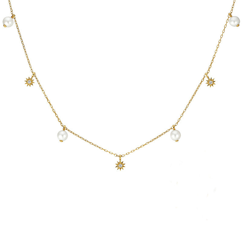Gold necklace with pearls and star-shaped charms on a white background
