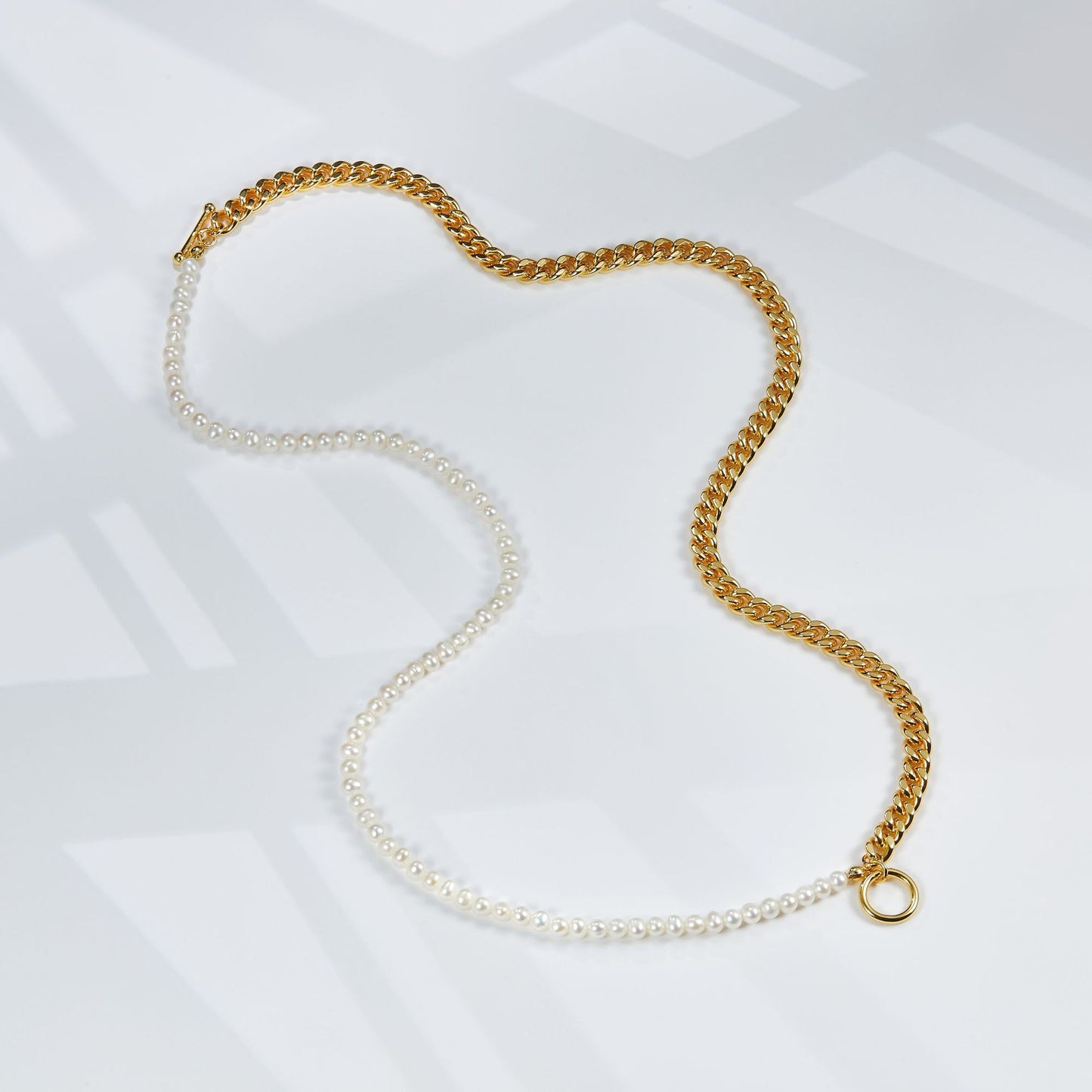 Gold and pearl necklace on a white background