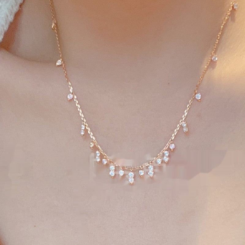 Delicate gold necklace with small crystals on a soft background