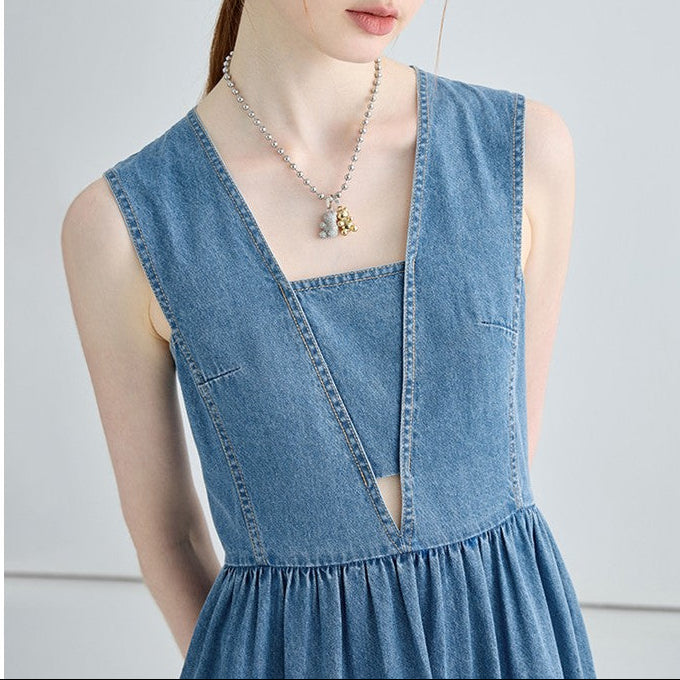 Woman wearing a blue denim dress with a plain background