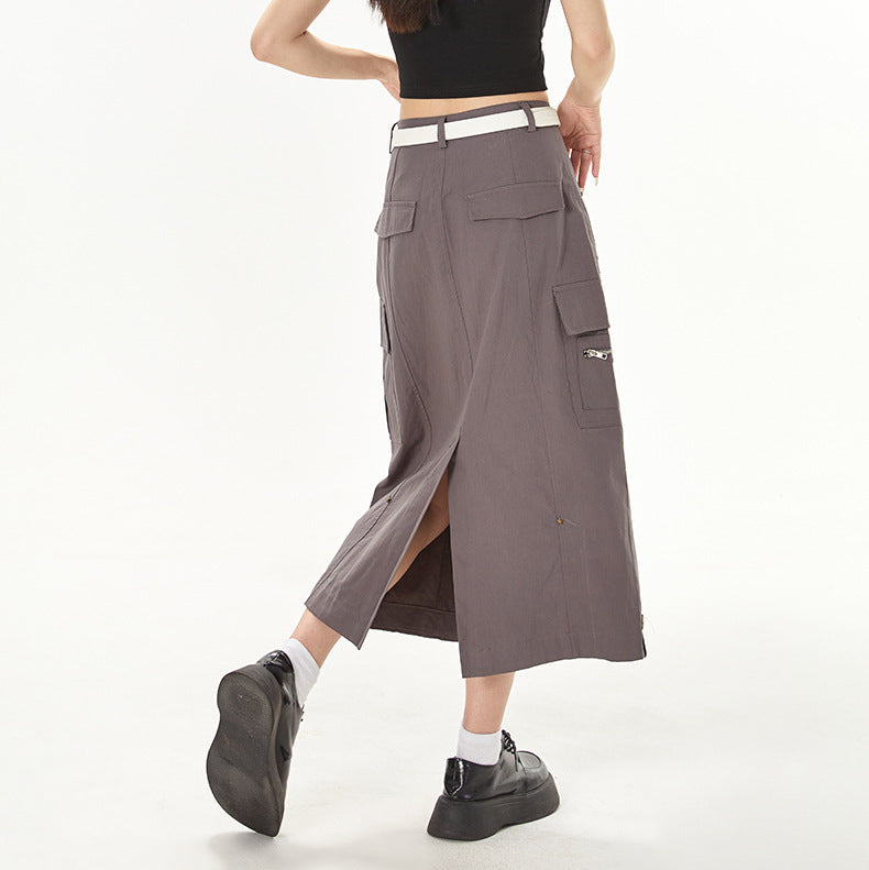 Woman wearing a black crop top and gray cargo skirt on a white background