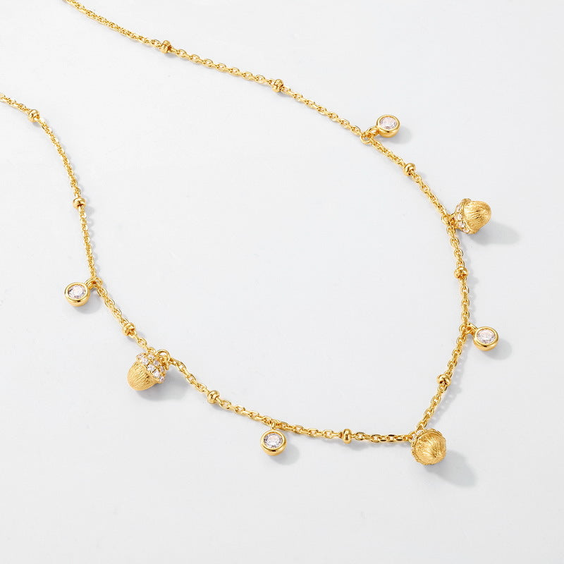 Gold necklace with small round pendants on a light gray background