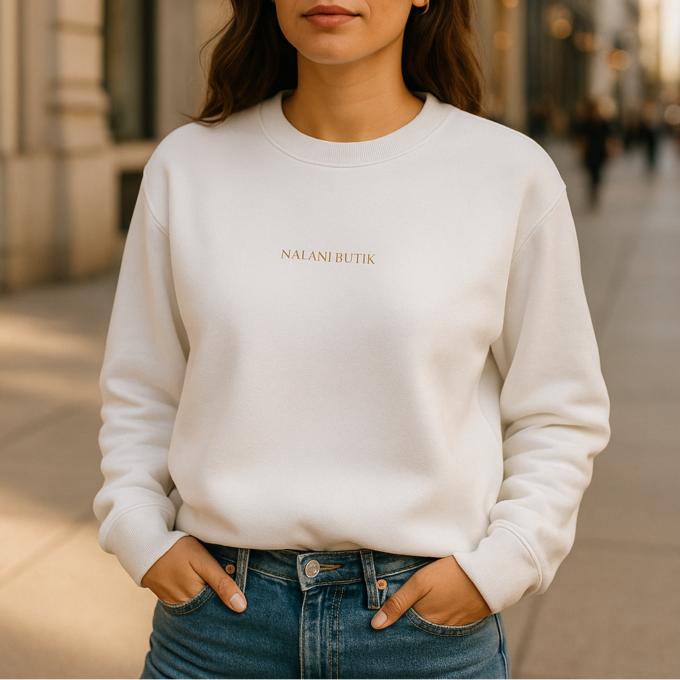 Woman wearing a white sweatshirt with text and sunglasses on a city street.