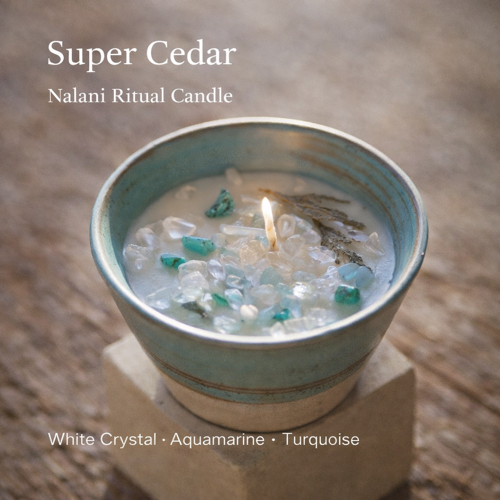 Candle in a ceramic container with visible crystals on a stone surface, labeled 'Super Cedar' and 'Nalani Ritual Candle'.