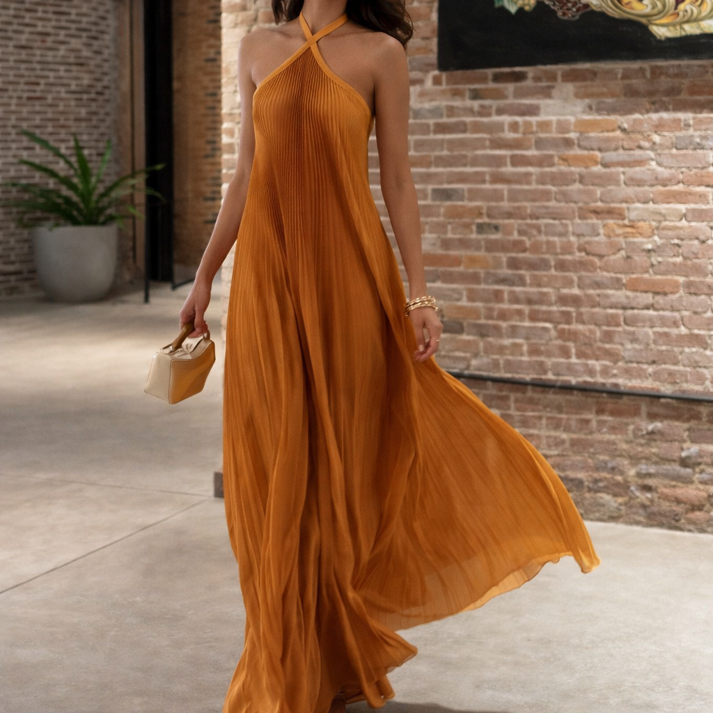 Woman in a mustard yellow dress standing in front of a brick wall.